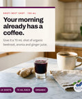 Serving suggestion: Small glass of Shoti Beet Shot next to a coffee cup and ginger root on a kitchen counter