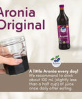 Organic Aronia Juice 700 ml glass bottle – Canada packaging, bottle next to a glass of juice