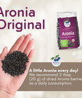 Organic Dried Aronia Berries 200 g pouch – Canada packaging, with a handful of dried berries
